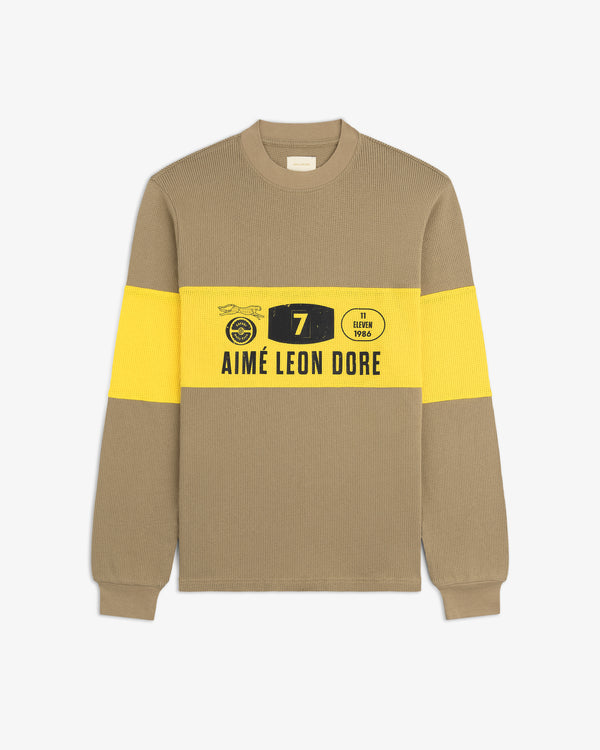 Beige and yellow Long-Sleeve Rally Tee with bold graphic and AIMÉ LEON DORE text across the chest.