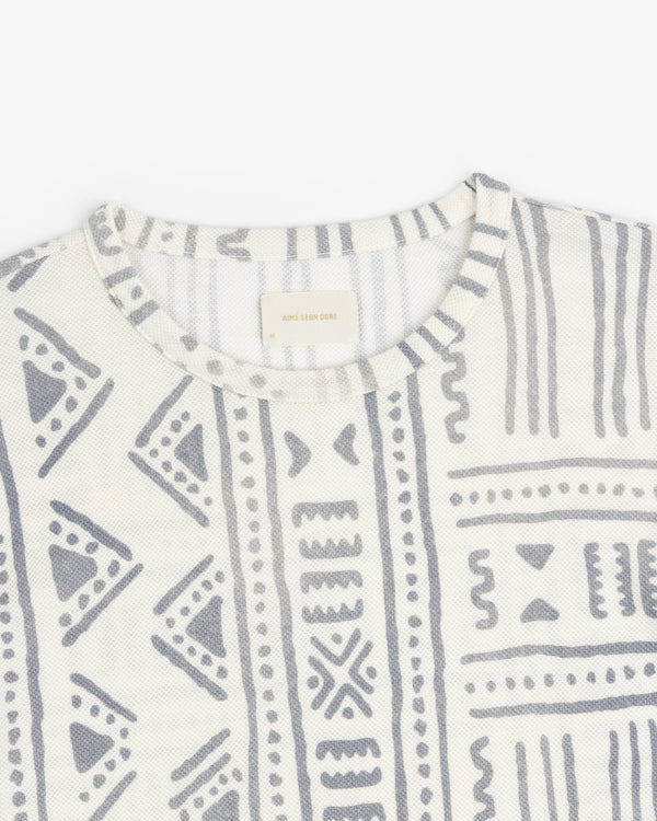 Long-Sleeve Mesh Tapestry Tee in white with light gray geometric and tribal patterns, shown from neckline and chest.