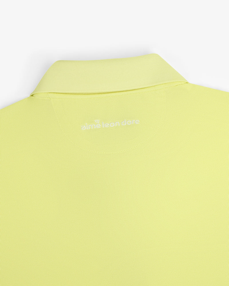 A close-up of the back collar of the light yellow ALD Golf Polo with "alml éean done" printed in white.