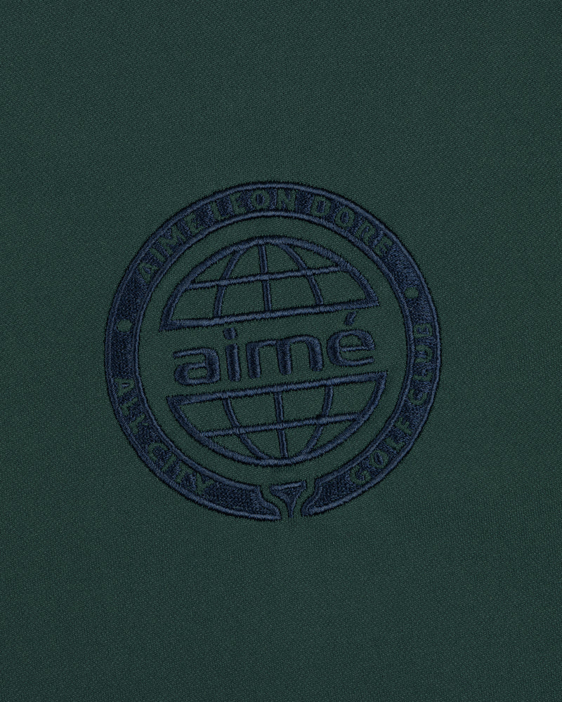 Dark green ALD Golf Tour Polo with a navy globe logo and "Aimé Leon Dore All City Golf Club" circle embroidery.