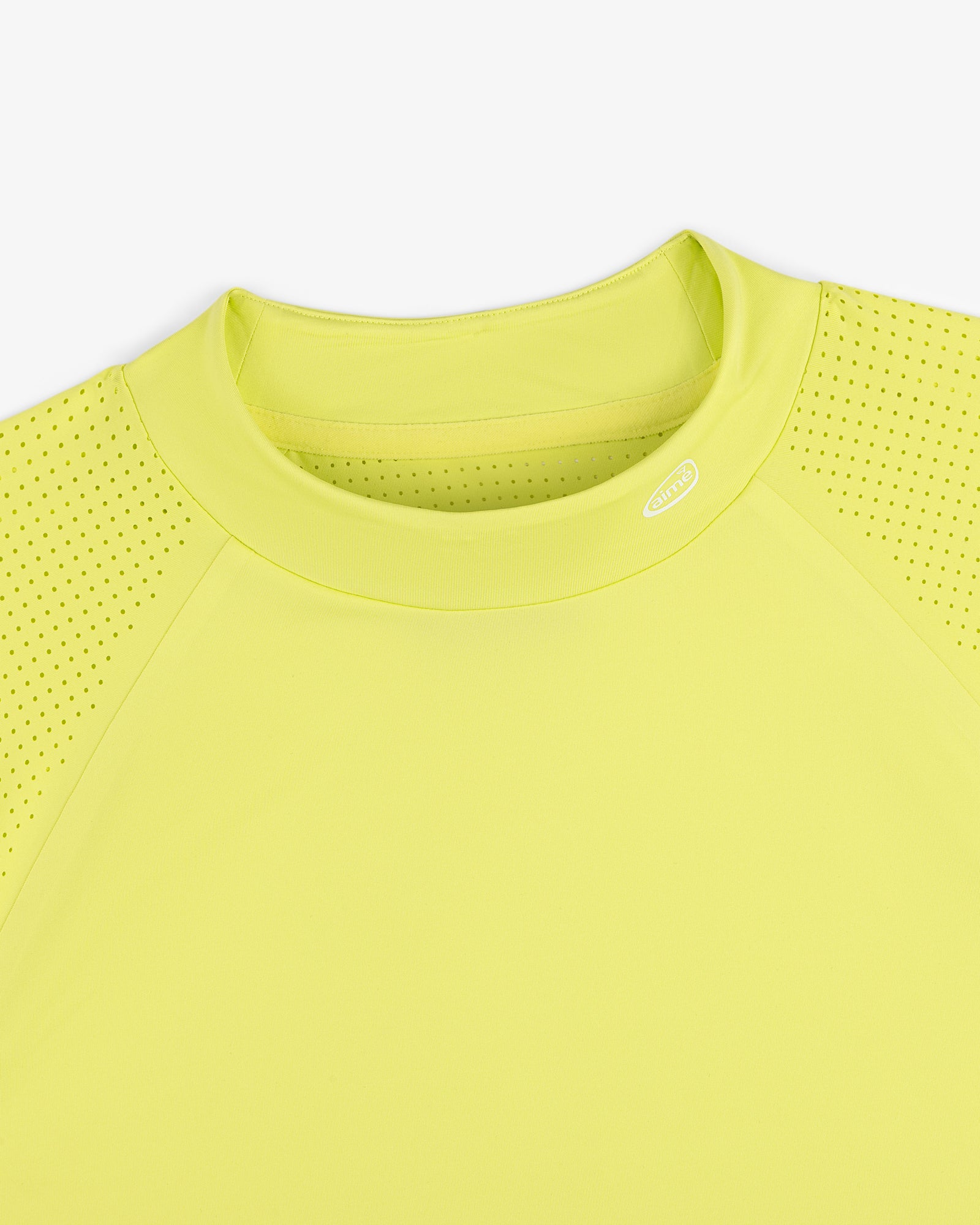 Close-up of the ALD Golf Performance Tee in yellow, featuring perforated sleeves and a round neck on white background.