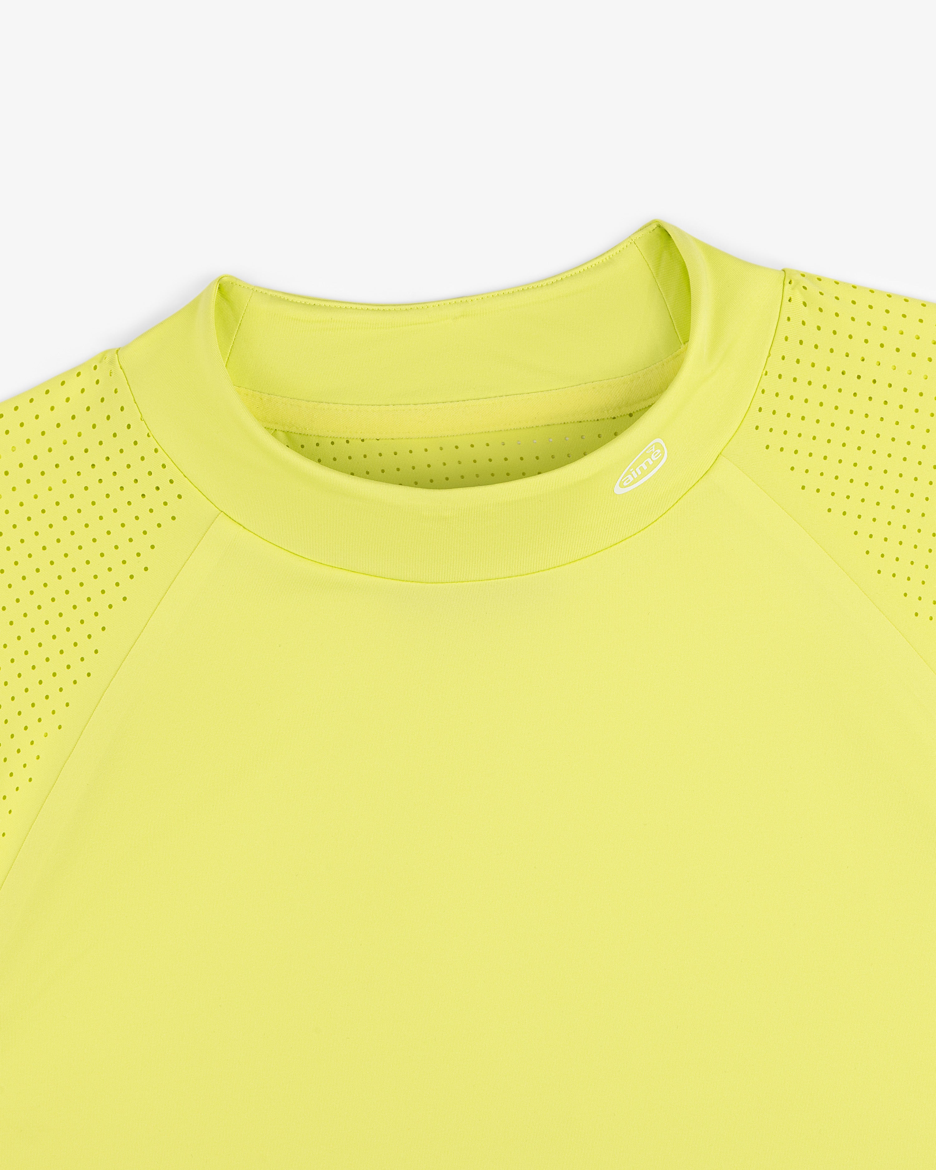 Close-up of the ALD Golf Performance Tee in yellow, featuring perforated sleeves and a round neck on white background.