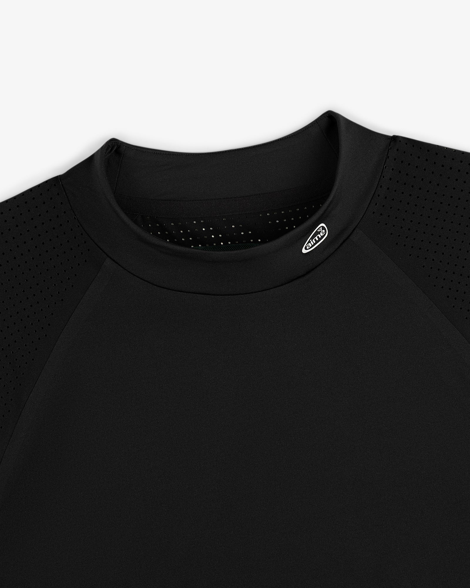 Close-up of the ALD Golf Performance Tee in black with perforated sleeves and a small logo near the collar.