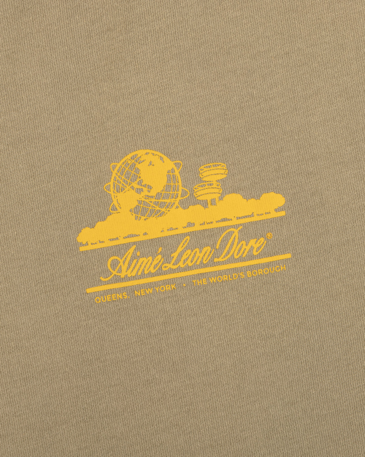 Tan Sun Faded Unisphere Tee with yellow globe and buildings graphic, Aimé Leon Dore text, and Queens, New York.