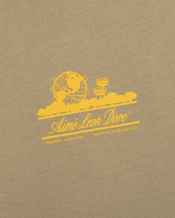 Tan Sun Faded Unisphere Tee with yellow globe and buildings graphic, Aimé Leon Dore text, and Queens, New York.
