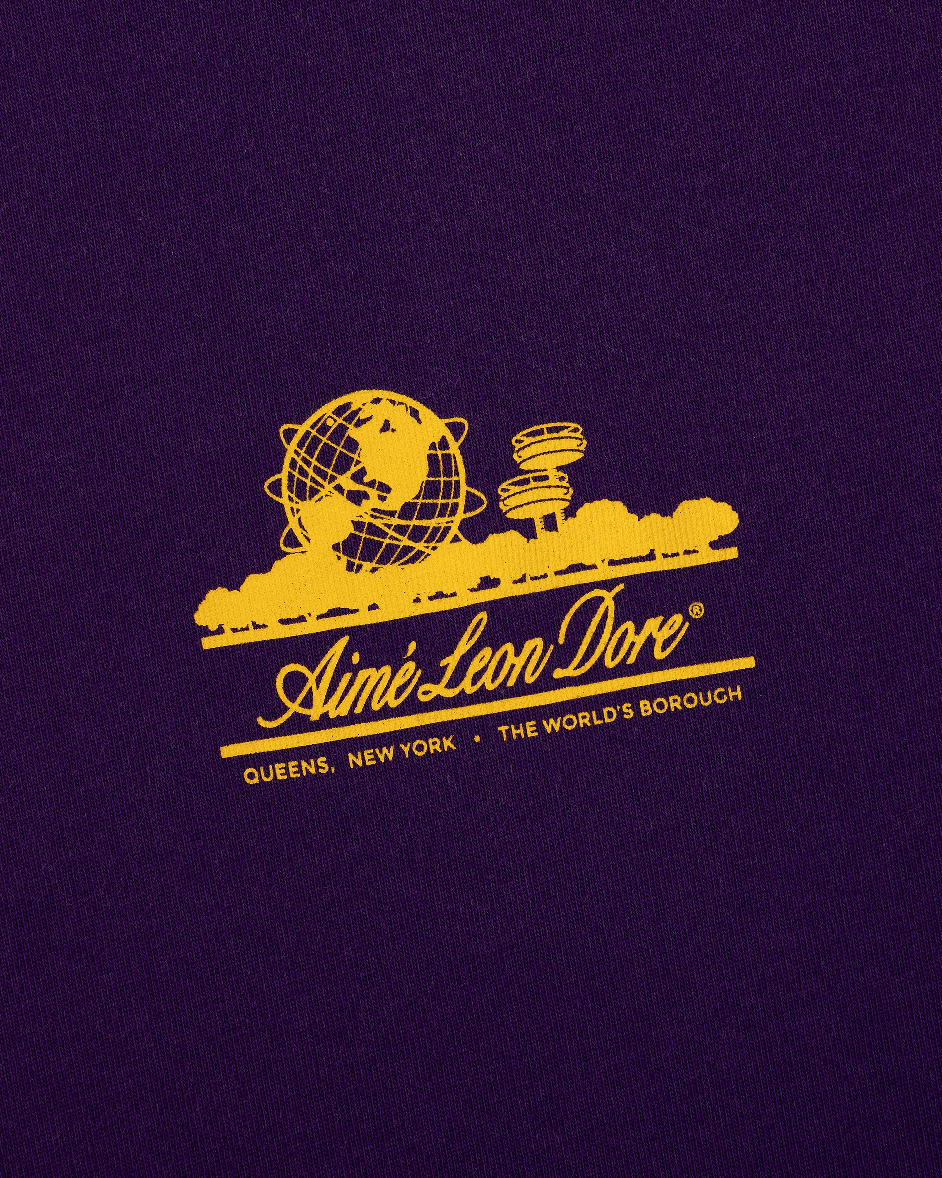 Sun Faded Unisphere Tee: Yellow Unisphere graphic and Aimé Leon Dore text on purple with Queens, NY below.