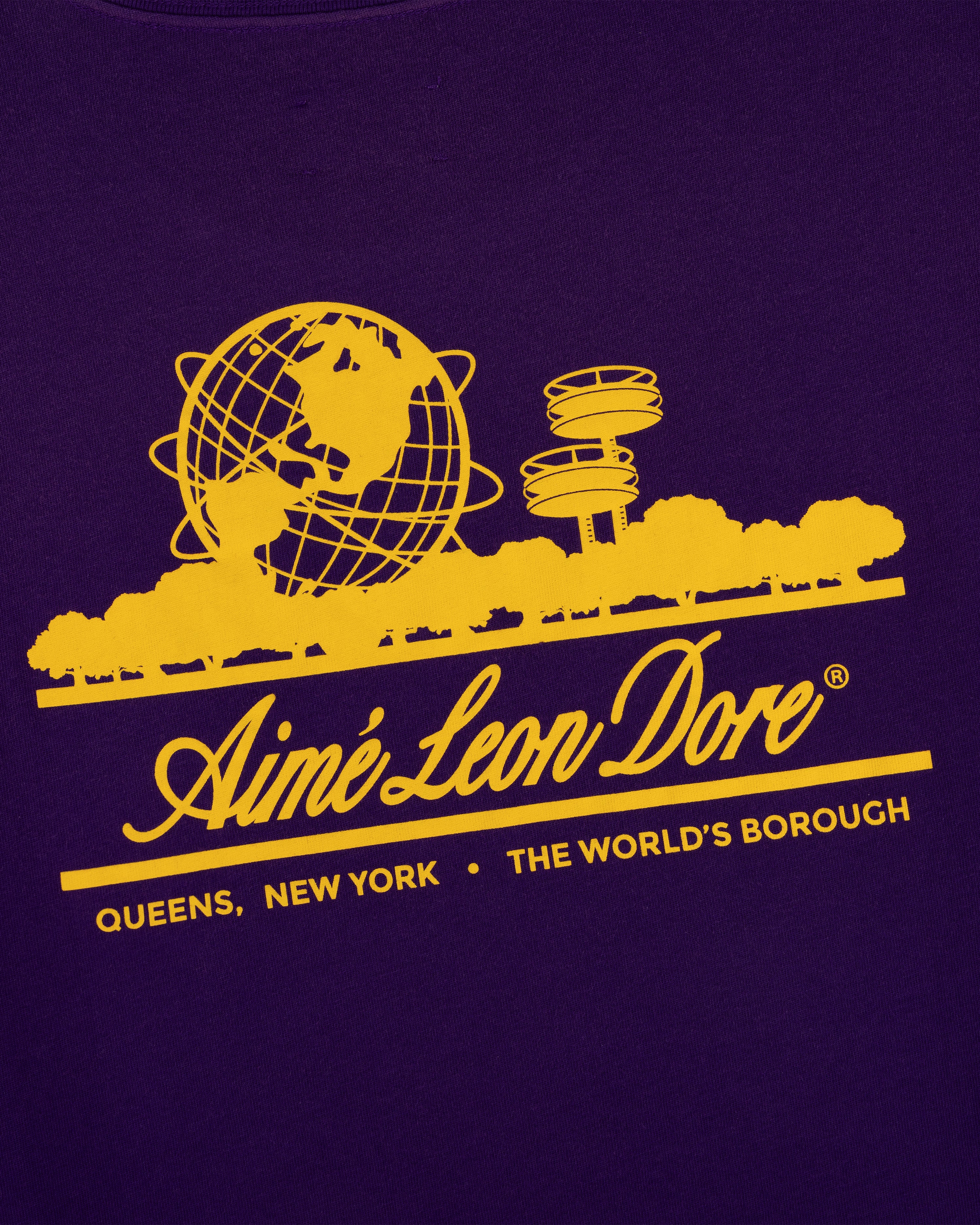 Yellow Aimé Leon Dore globe logo and NY landmarks on purple Sun Faded Unisphere Tee. Text: Queens, New York.