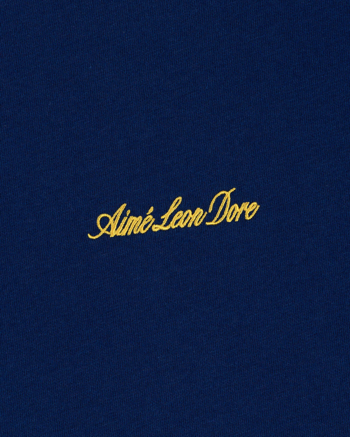 Navy blue Embroidered Logo Tee with yellow Aimé Leon Dore cursive text.