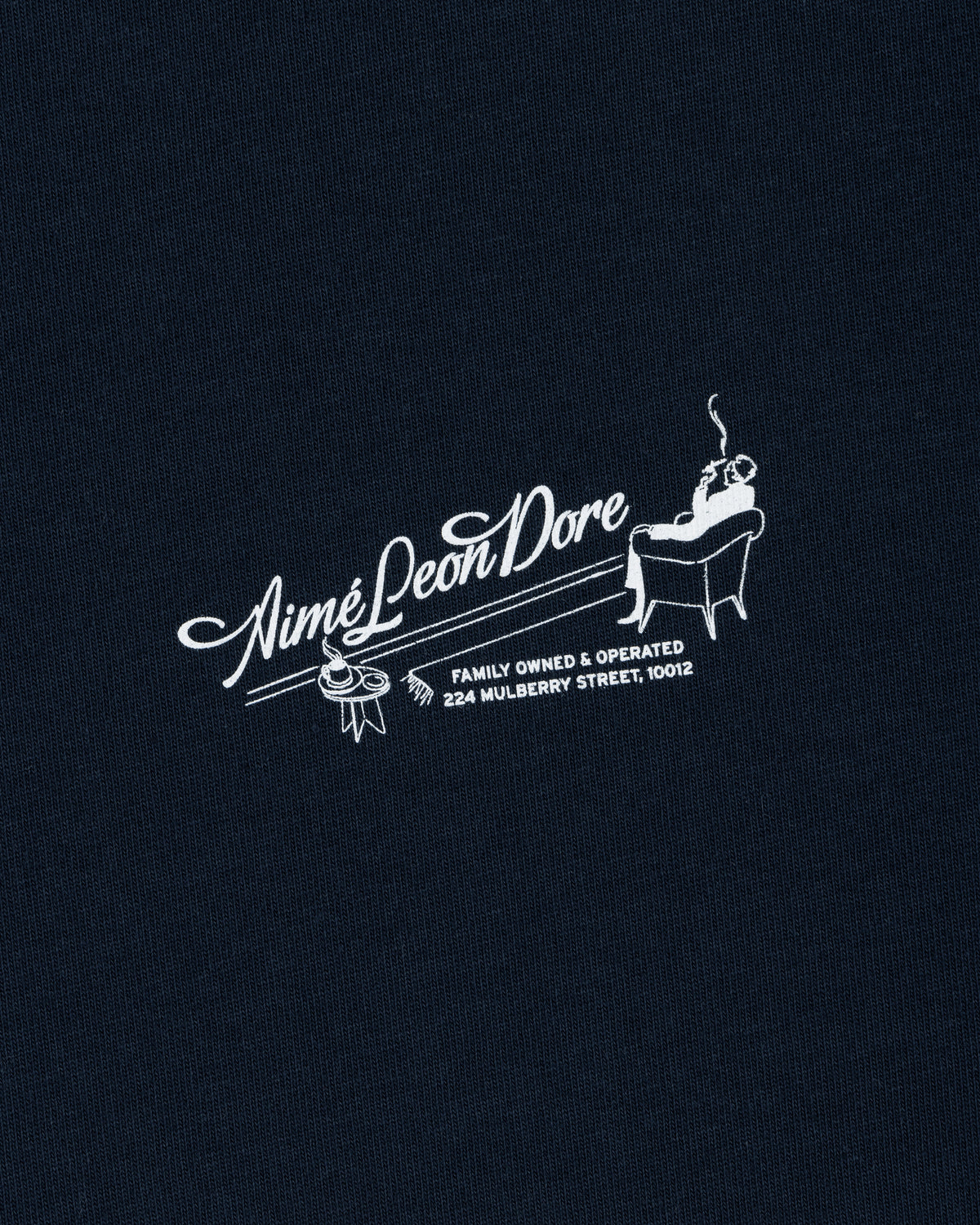 Pappoús Logo Tee: White Aimé Leon Dore logo of a man relaxing, text reads Family Owned & Operated, 224 Mulberry St, 10012.