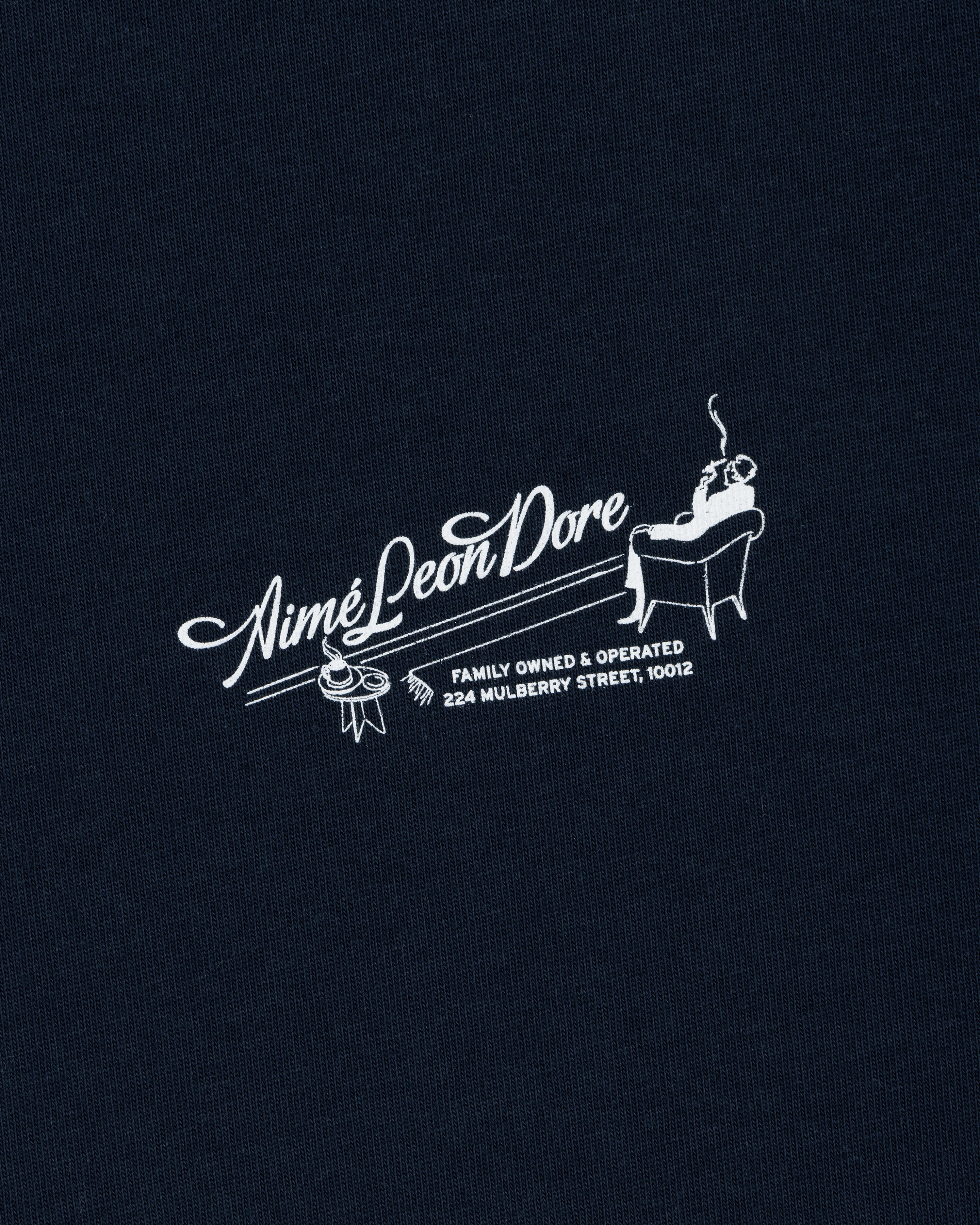 Pappoús Logo Tee: White Aimé Leon Dore logo of a man relaxing, text reads Family Owned & Operated, 224 Mulberry St, 10012.