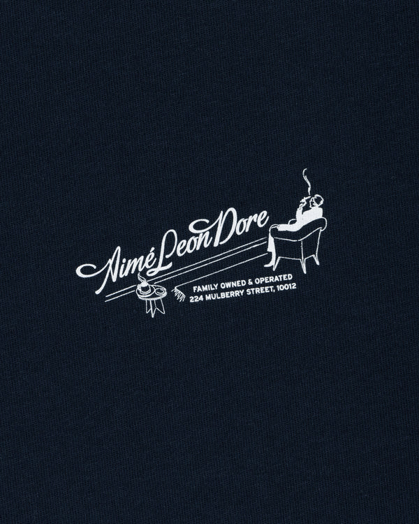 Pappoús Logo Tee: White Aimé Leon Dore logo of a man relaxing, text reads Family Owned & Operated, 224 Mulberry St, 10012.