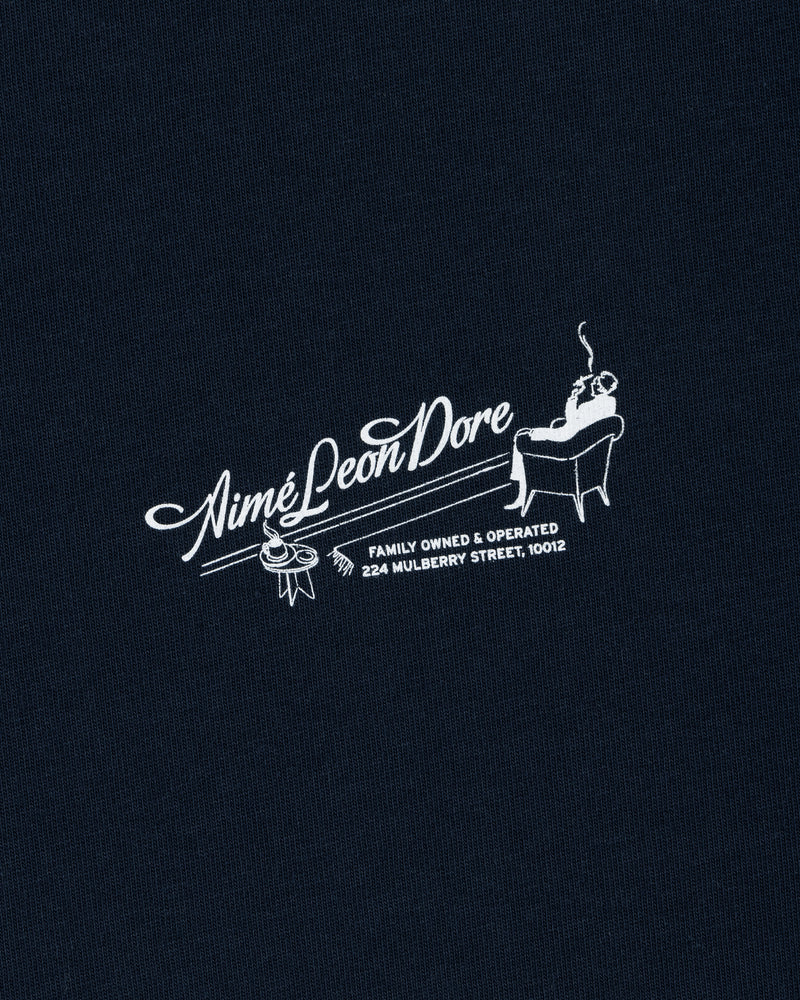 Pappoús Logo Tee: White Aimé Leon Dore logo of a man relaxing, text reads Family Owned & Operated, 224 Mulberry St, 10012.