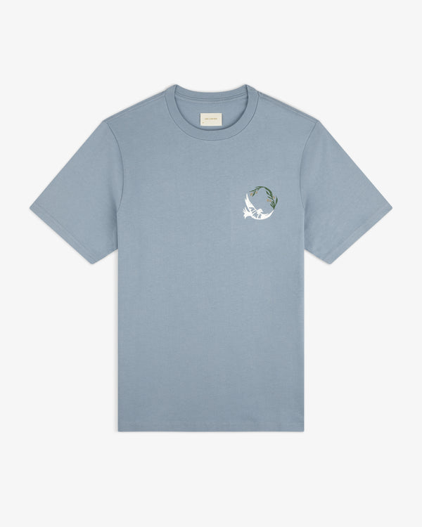 Woodblock Dove Tee: light blue short-sleeve featuring a small white bird and green leaves on the left chest.