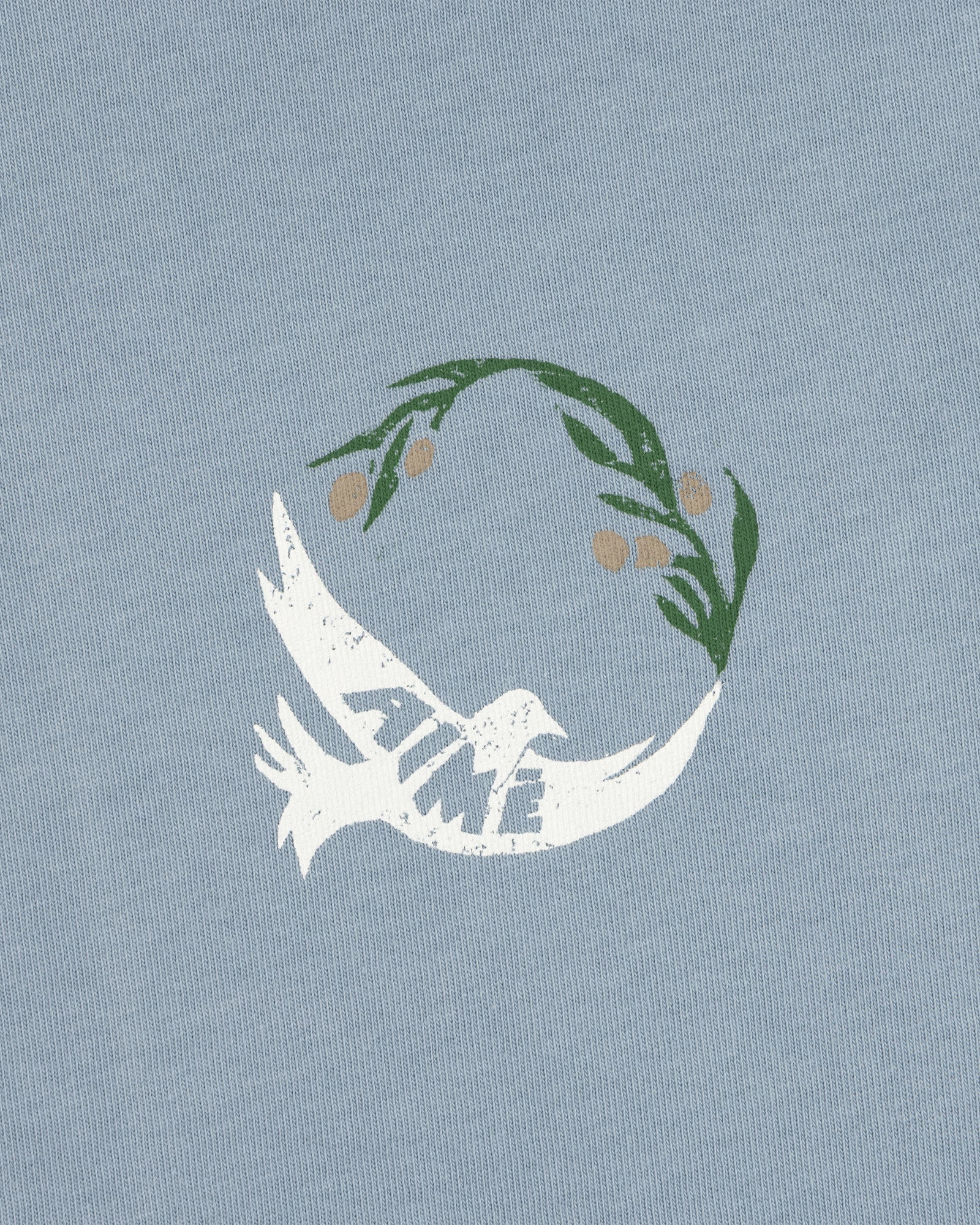 White dove with TIME on its wing and olive branch above on a light blue Woodblock Dove Tee.