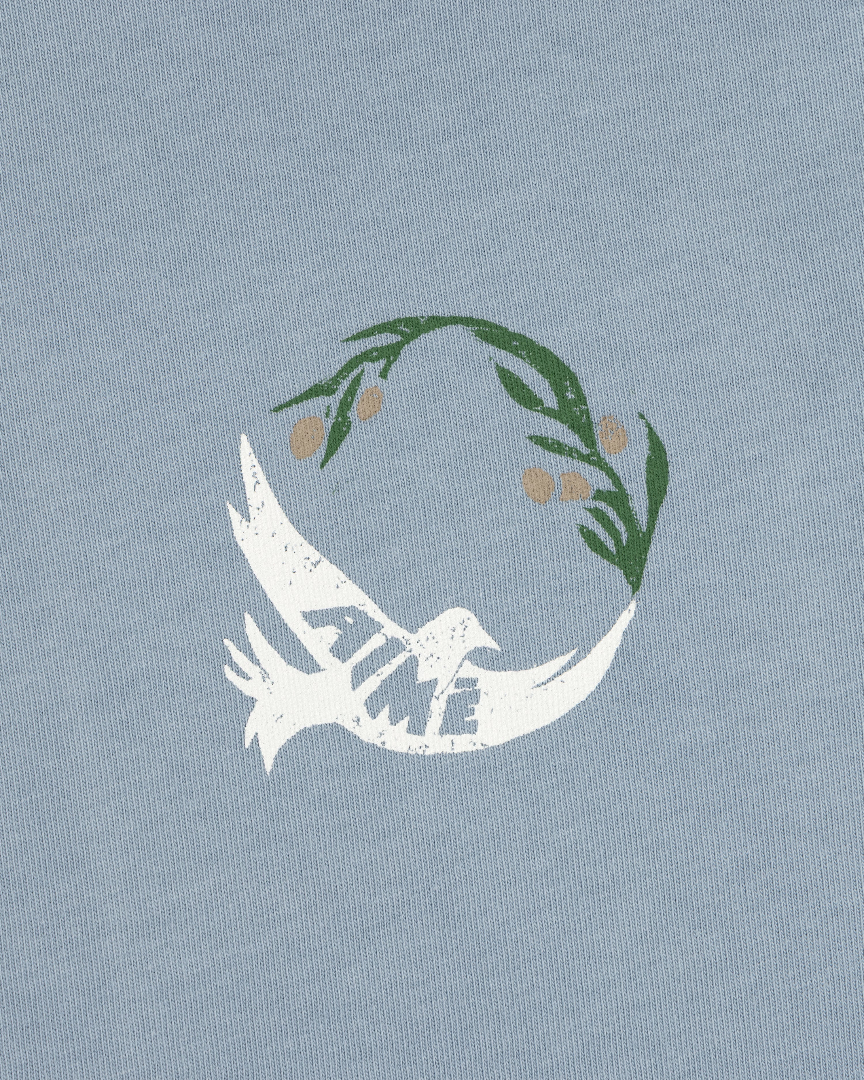 White dove with TIME on its wing and olive branch above on a light blue Woodblock Dove Tee.