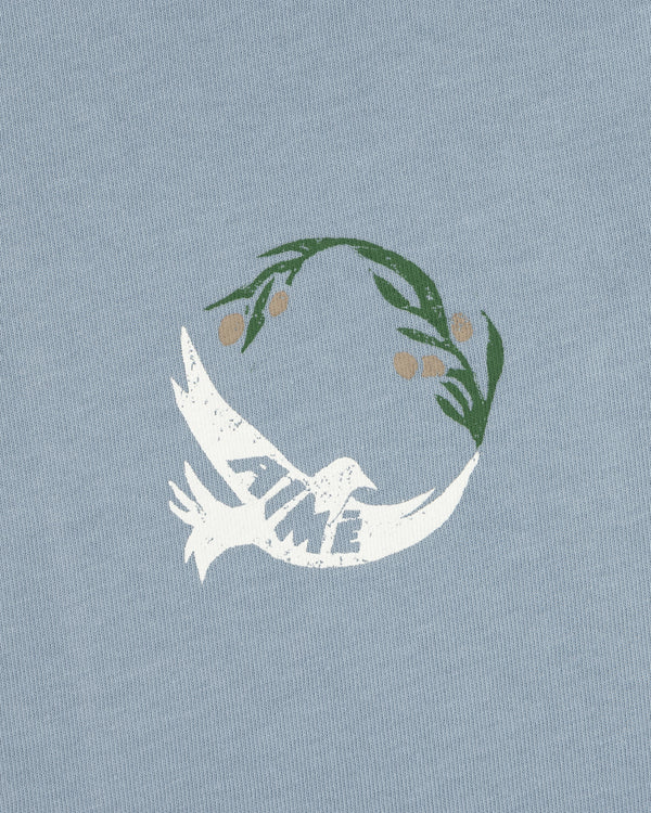 White dove with TIME on its wing and olive branch above on a light blue Woodblock Dove Tee.
