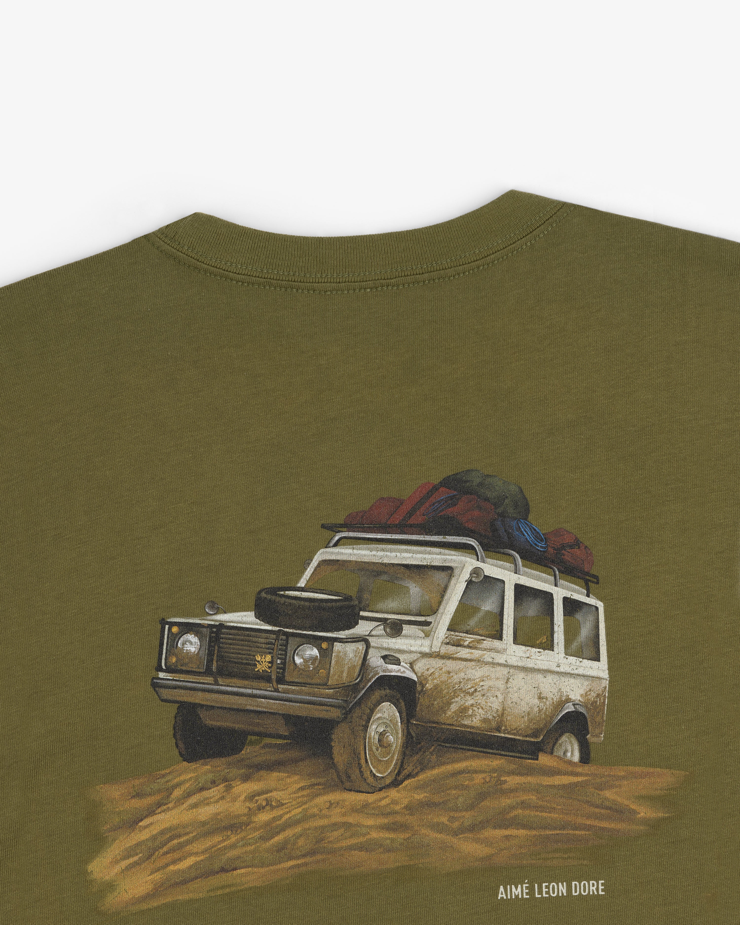 Safari Tee with illustrated off-road vehicle in mud and “AIMÉ LEON DORE” printed below.
