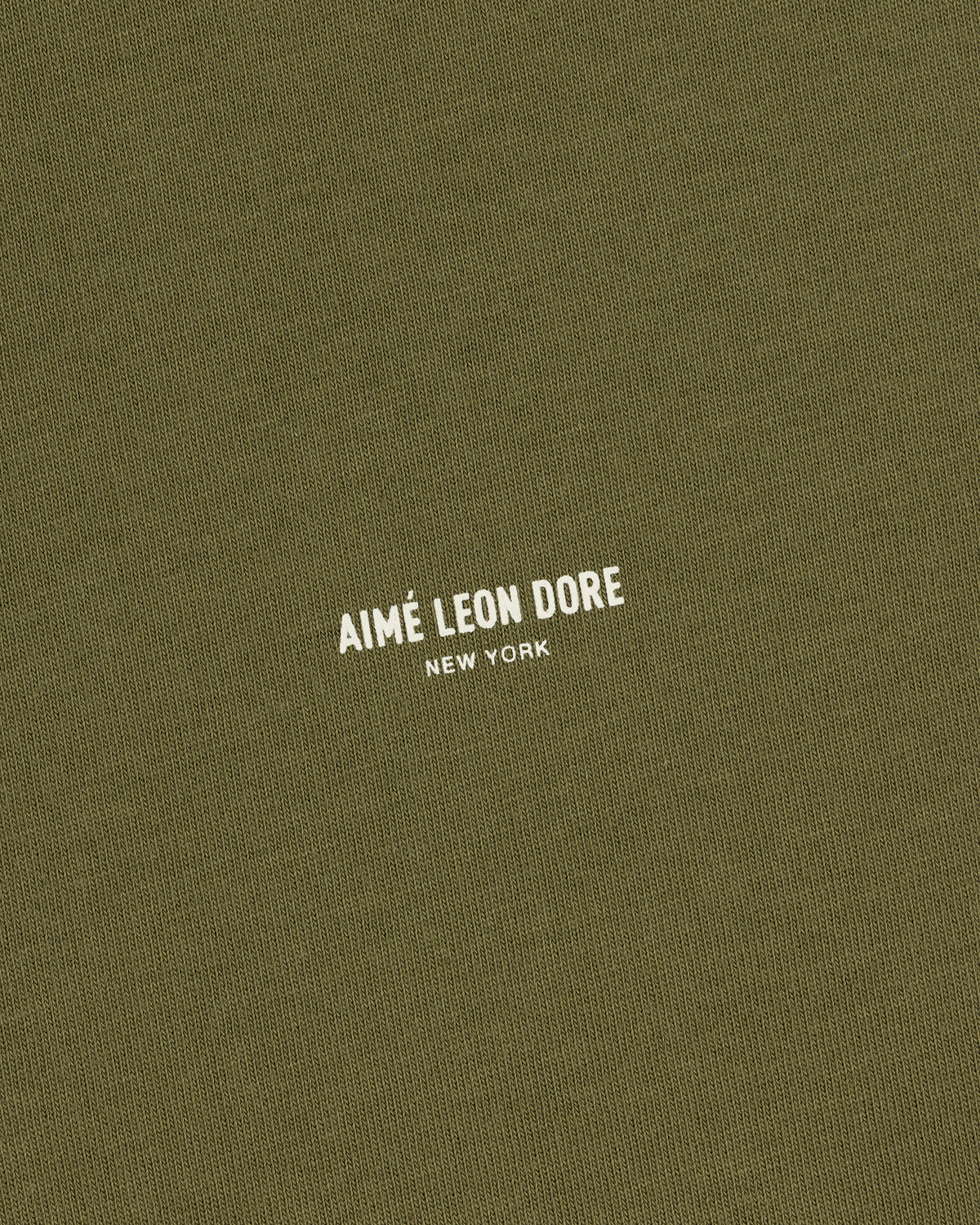 Olive green Safari Tee with small white AIMÉ LEON DORE NEW YORK text printed in the center.