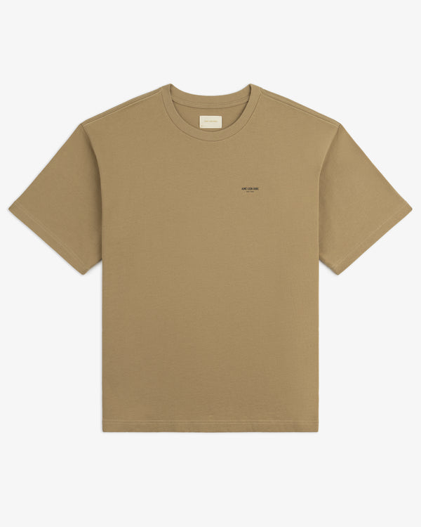 Safari Tee in plain khaki, short sleeves, small black text logo on chest, displayed flat on white background.