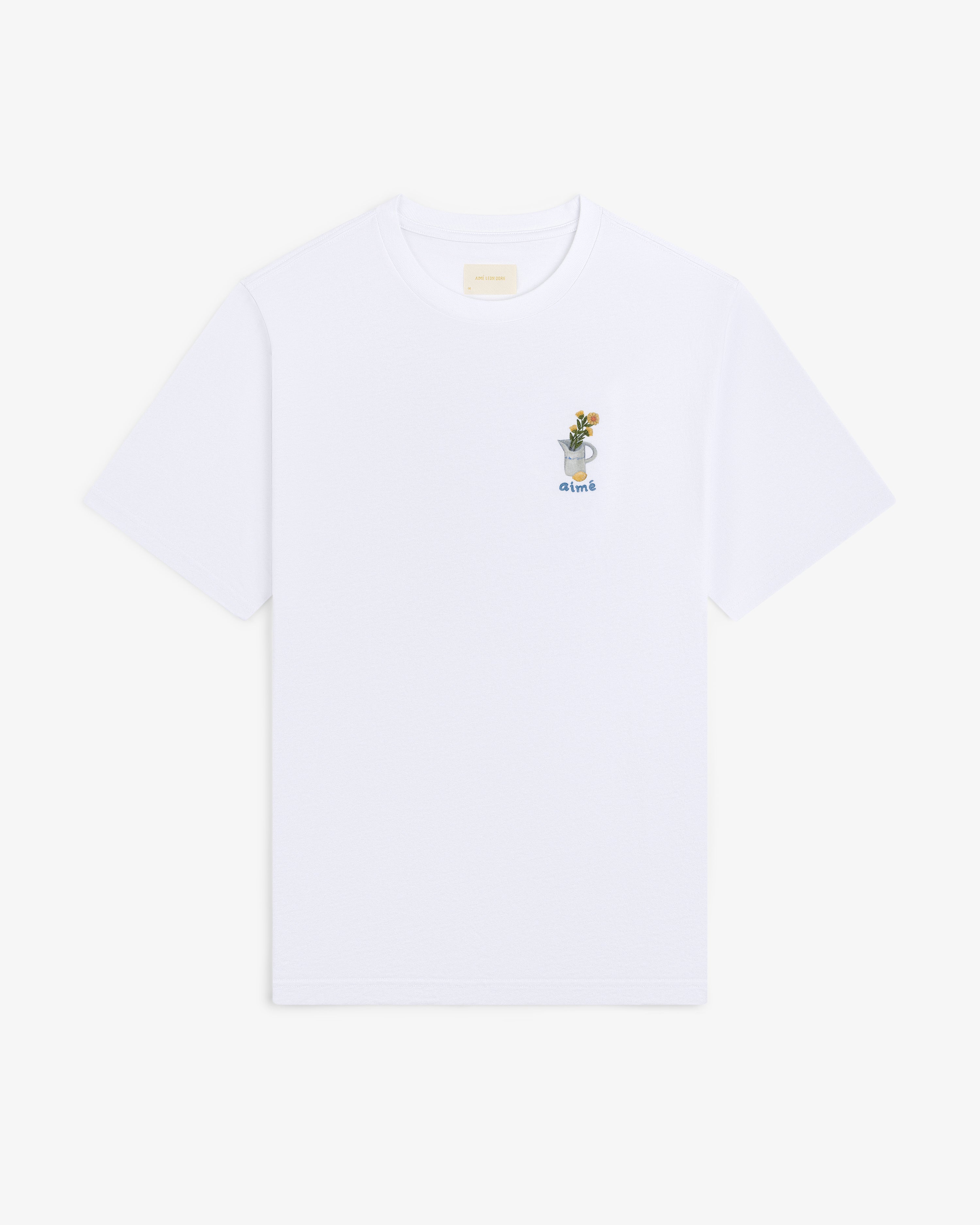 Breakfast Tee: White T-shirt featuring a small embroidered drink graphic and the word "drink" on the upper left chest.