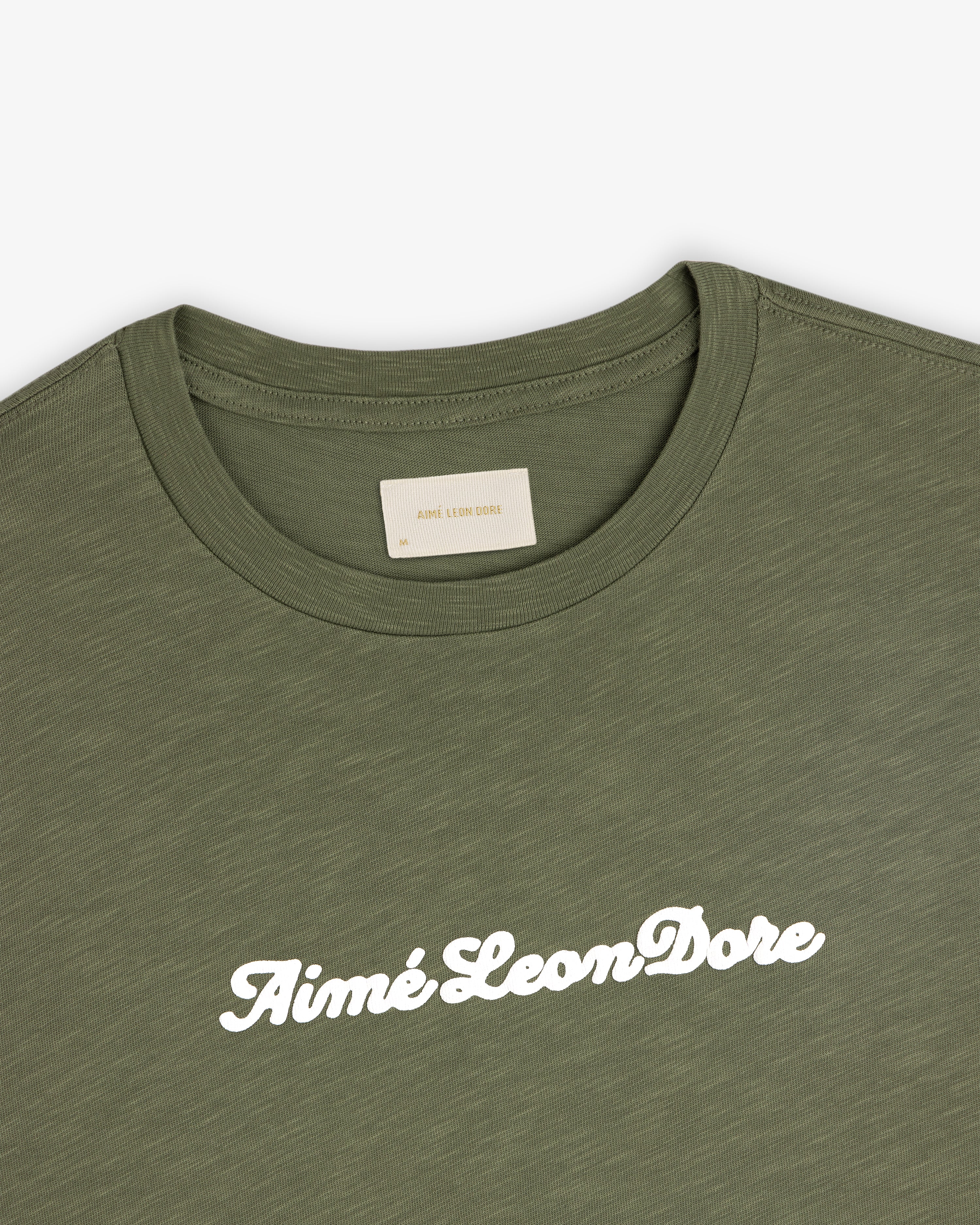 Olive green Puff Print Slub Logo Tee with Aimé Leon Dore in white cursive across the chest.