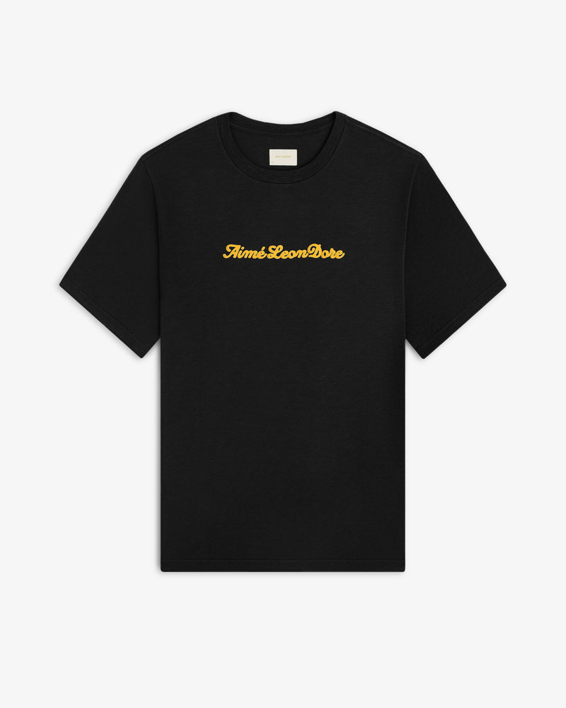Black Puff Print Slub Logo Tee with Aimé Leon Dore in yellow cursive text across the chest.
