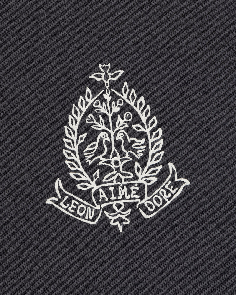White embroidery of two birds, leafy branches, and "LEON AIME DOPE" on the Saint George Graphic Tee.