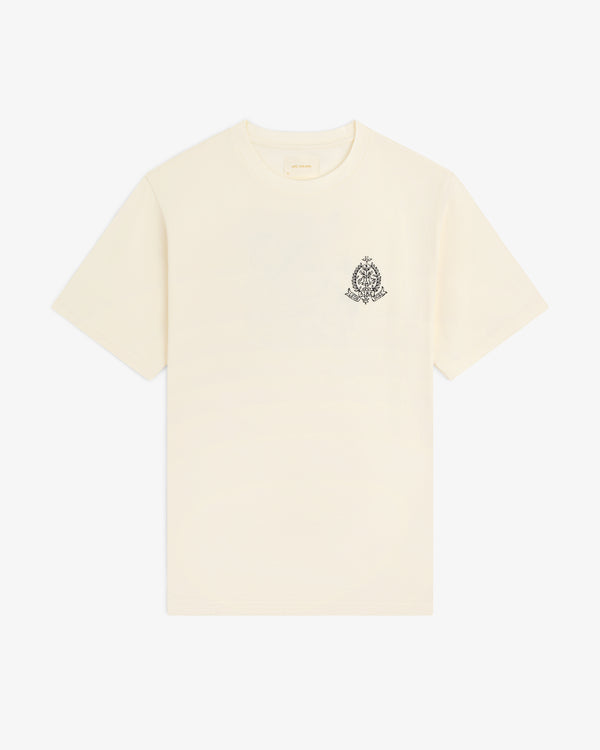 Saint George Graphic Tee: Cream short-sleeve shirt with small black crest logo on the left chest.