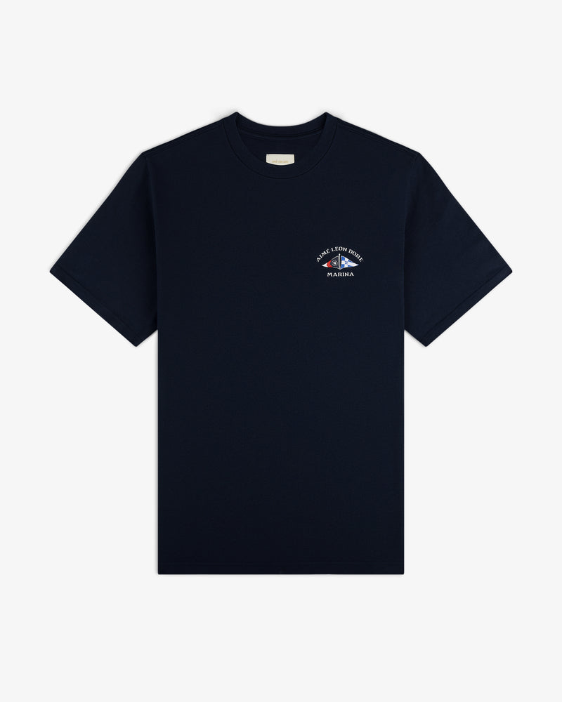 Marina Tee: Navy blue short-sleeve t-shirt with a small white logo and text on the left chest.