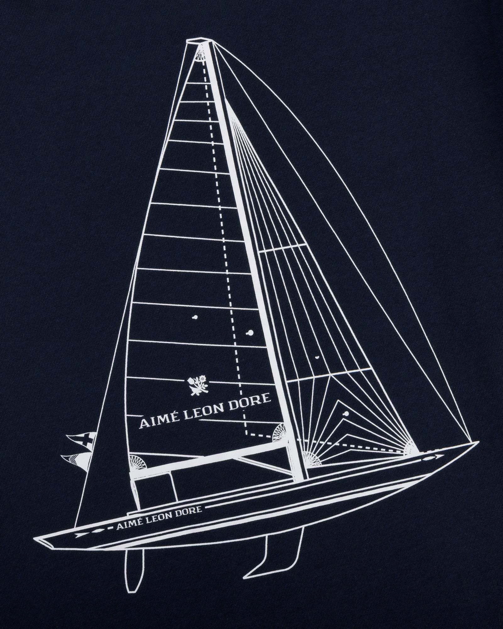 White line sailboat with Aimé Leon Dore text on sail and hull, on dark Marina Tee.