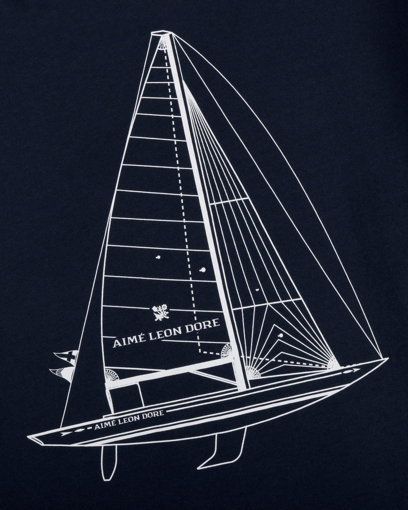 White line sailboat with Aimé Leon Dore text on sail and hull, on dark Marina Tee.