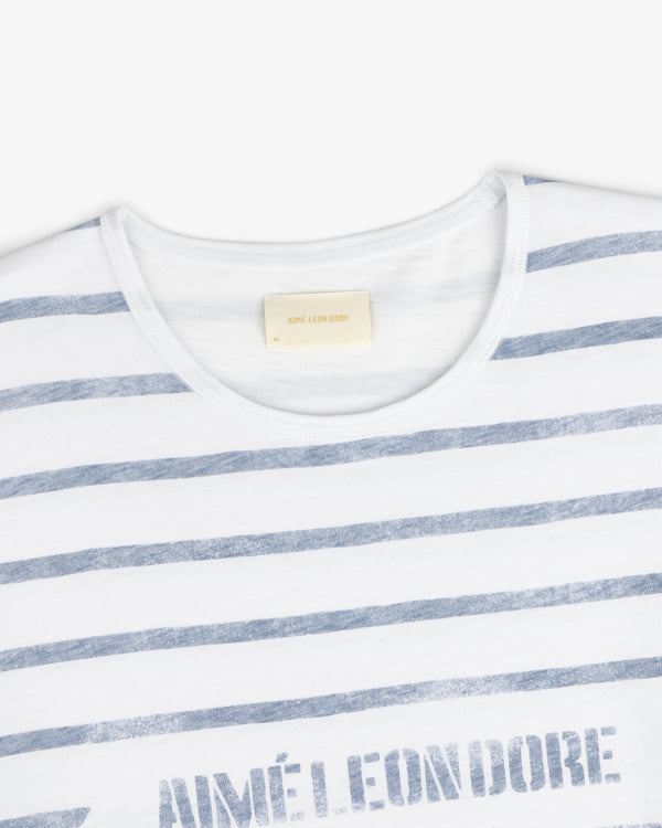 Slub Beach Tee: White tee with faded blue horizontal stripes and visible AIMÉ LEON DORE label inside the collar.