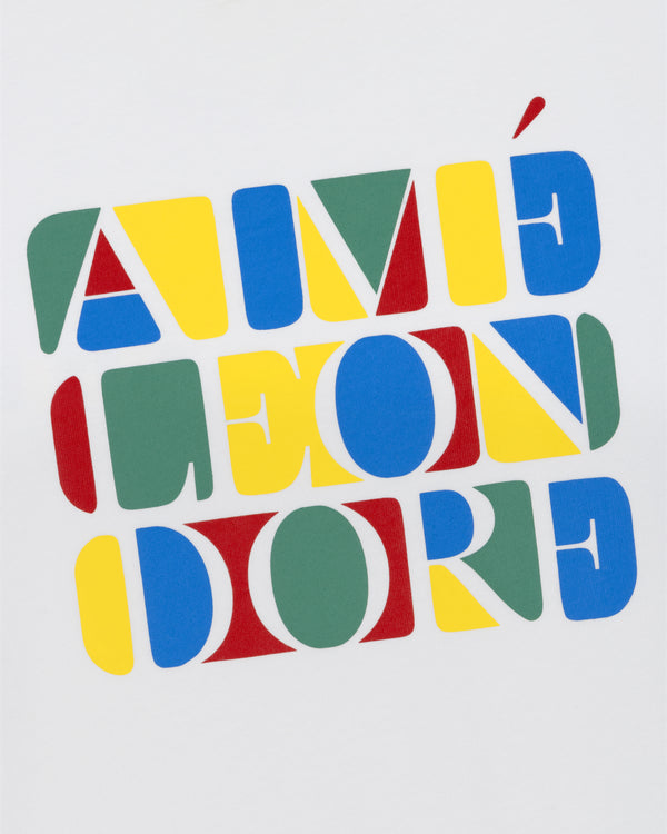 Colorful geometric shapes spell out "AIMÉ LEON DORE" on the white Stacked Logo Tee.