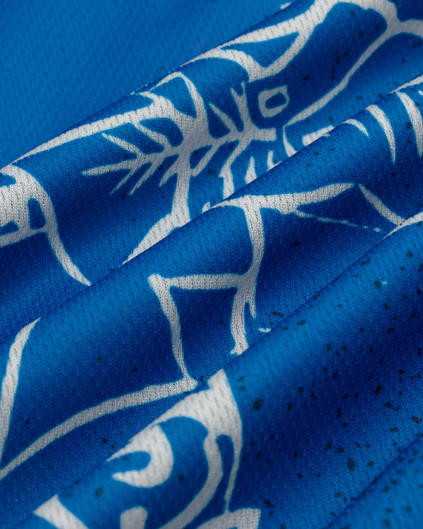 Close-up of the Fassianos Half-Zip Cycling Jersey's blue fabric with white abstract animal designs and visible stitching.