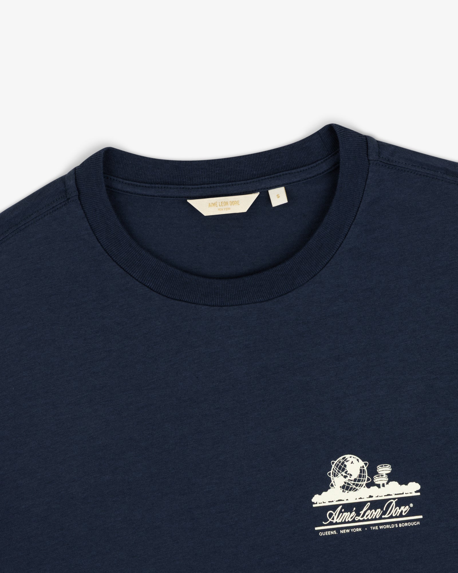 Cropped Aloe-Blend Unisphere Tee in navy blue with a small white graphic and text on the left chest.