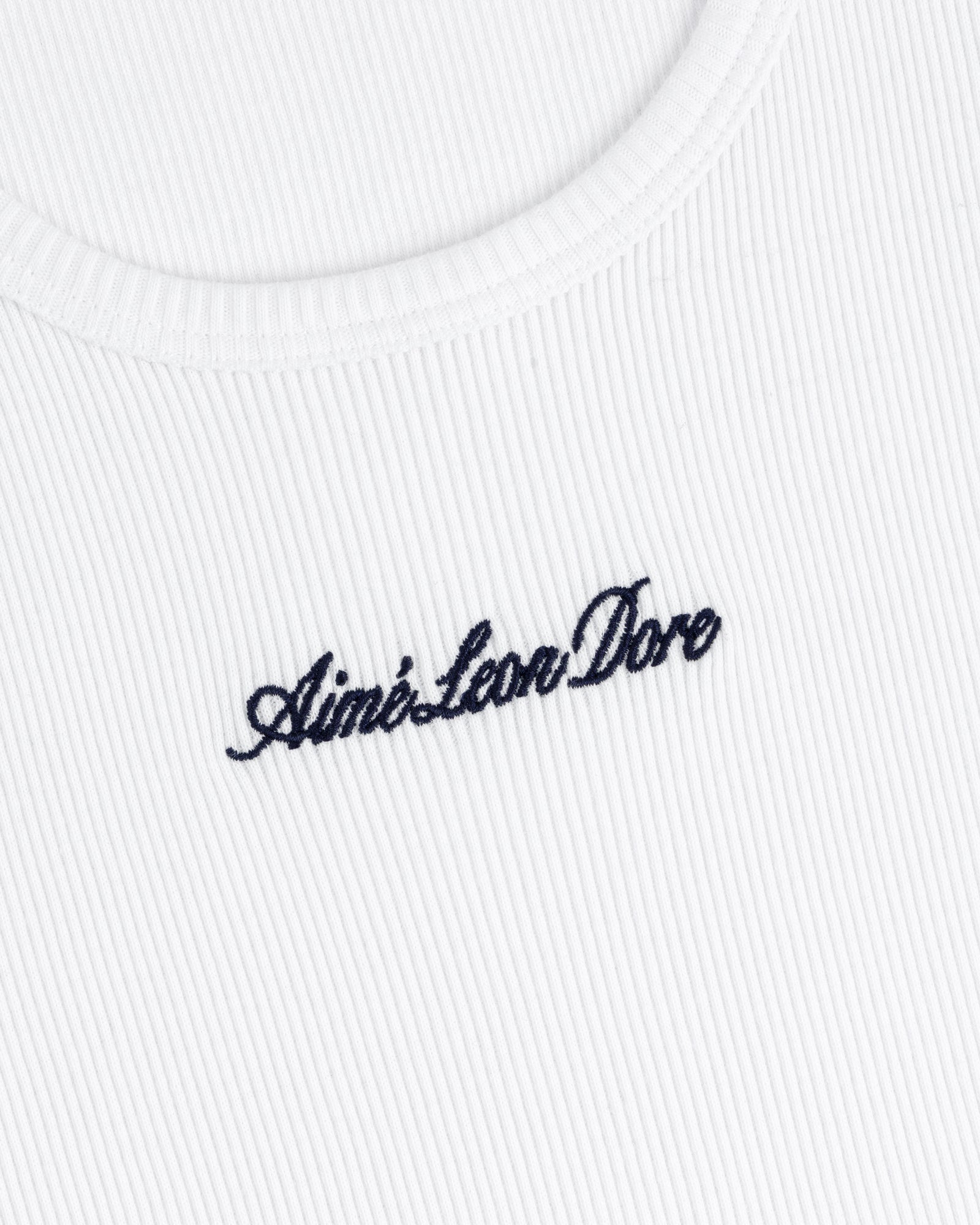 Close-up of a white ribbed Embroidered Logo Tank Top with Aimé Leon Dore in black cursive lettering.