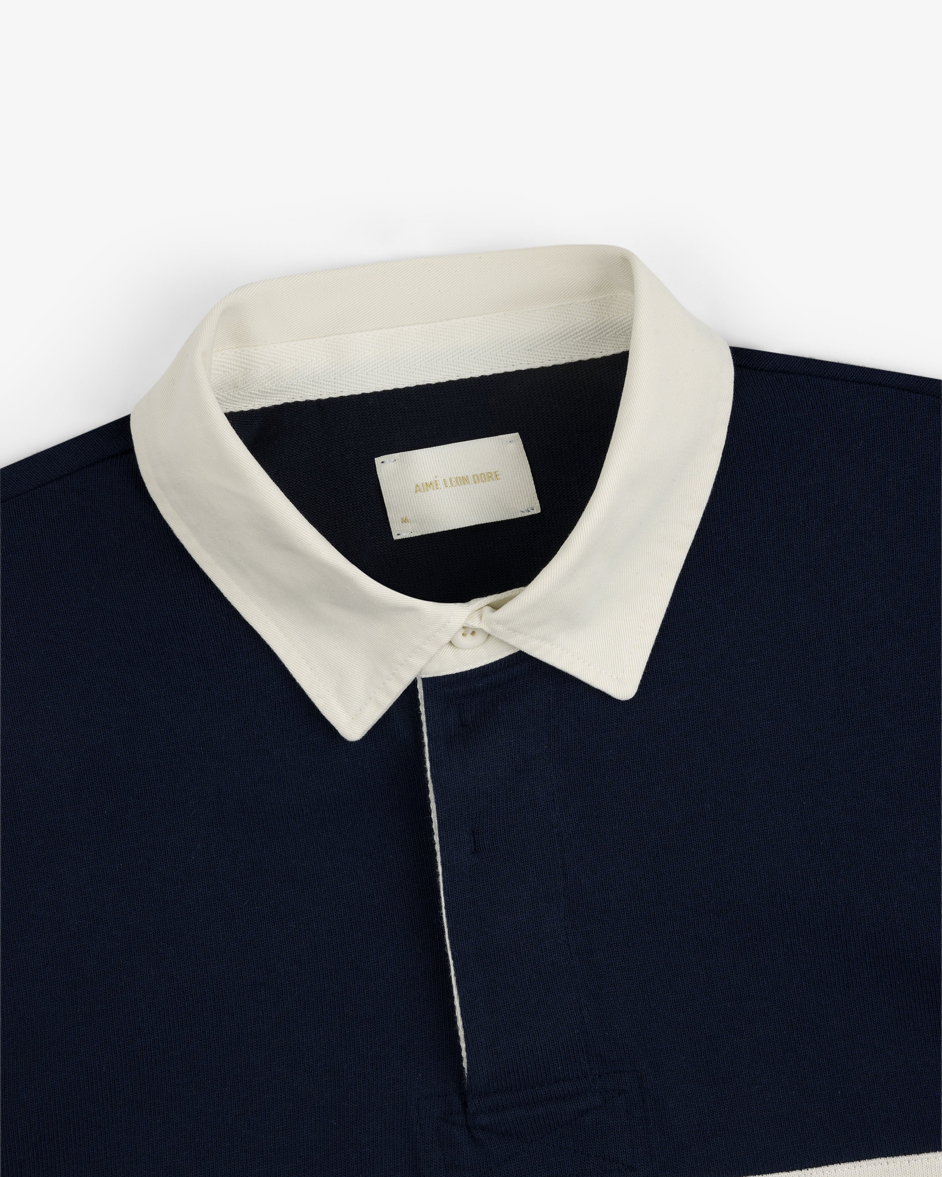 Navy blue Script Paneled Rugby with a white pointed collar and an AIME LEON DORE label inside.