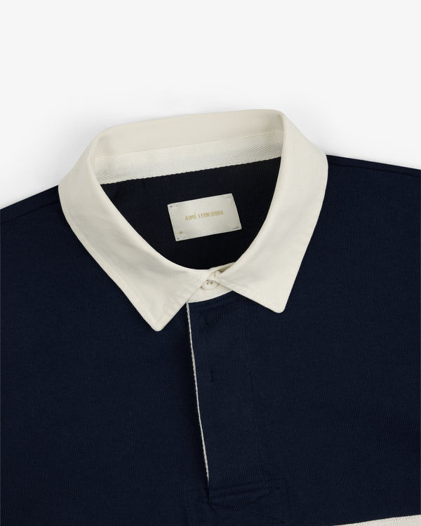 Navy blue Script Paneled Rugby with a white pointed collar and an AIME LEON DORE label inside.
