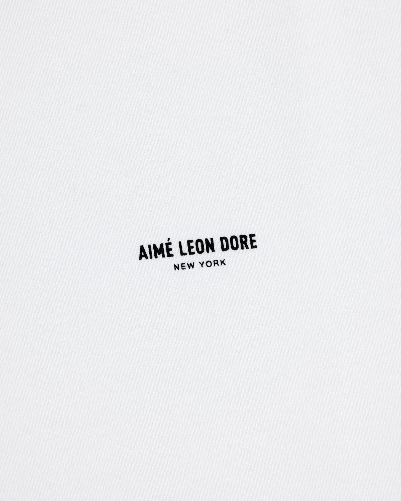 White Long-Sleeve Micro Logo Tee with small black "AIMÉ LEON DORE NEW YORK" text in the center.