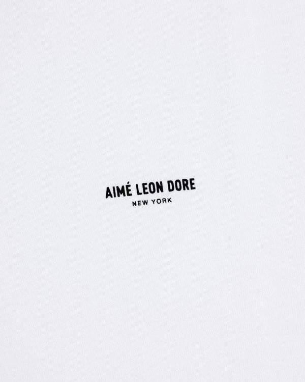 White Long-Sleeve Micro Logo Tee with small black "AIMÉ LEON DORE NEW YORK" text in the center.