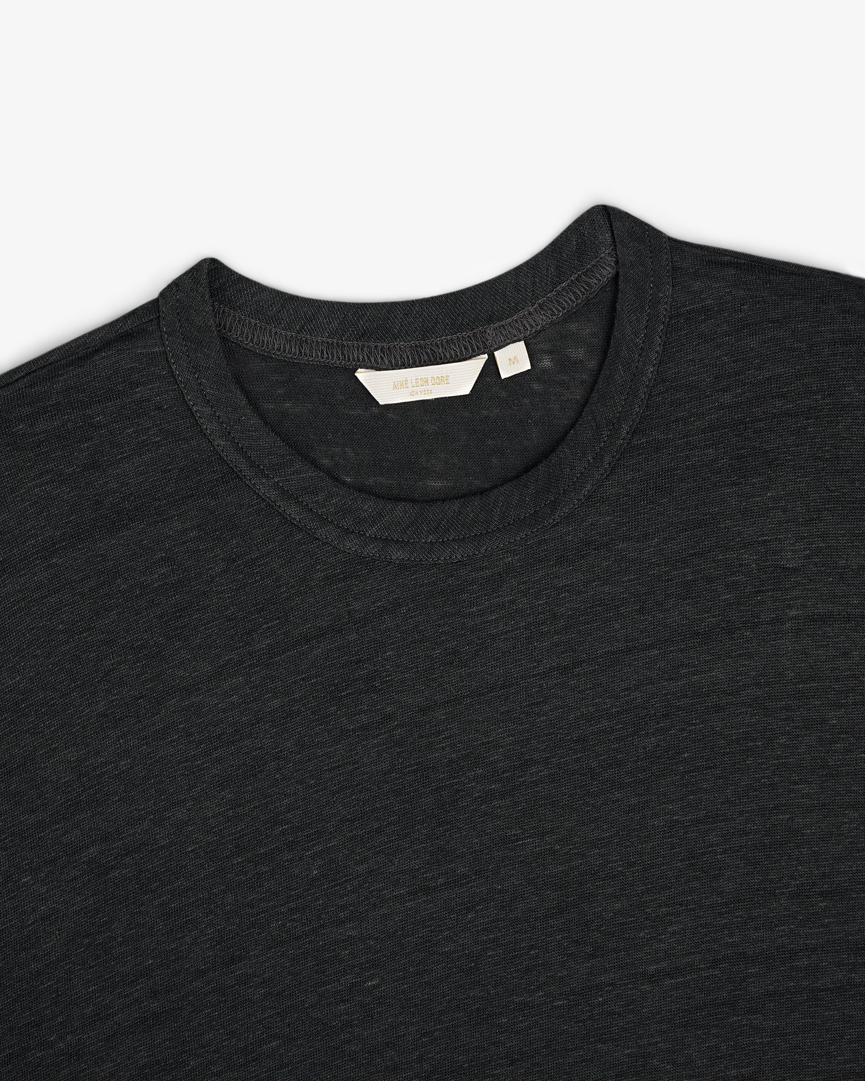 Linen Tee in dark gray, crew neck style, laid flat to display upper chest, collar, and inner neckline tag.