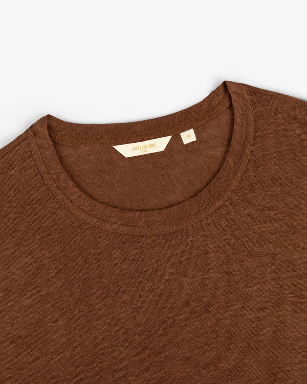 Long-sleeve linen tee laid flat, displaying the crew neck collar and inner label with size and brand details.