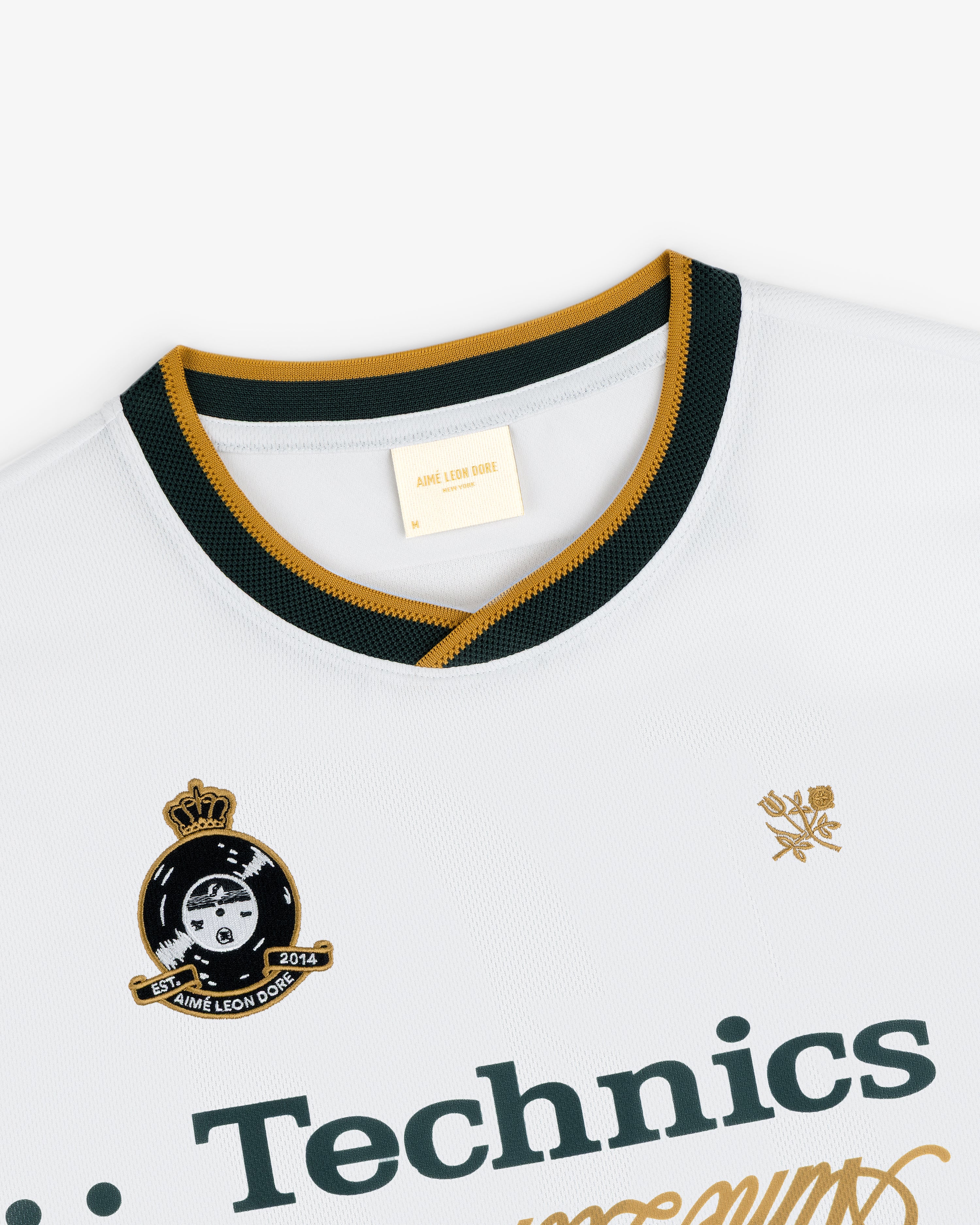 ALD / Technics Soccer Jersey: white with black and gold trim, Technics logo, crest, and Aimé Leon Dore collar label.