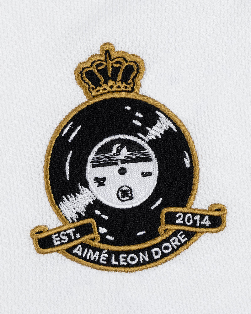 The ALD / Technics Soccer Jersey features a black and gold embroidered crest with a crown, record, and 2014 text on white fabric.