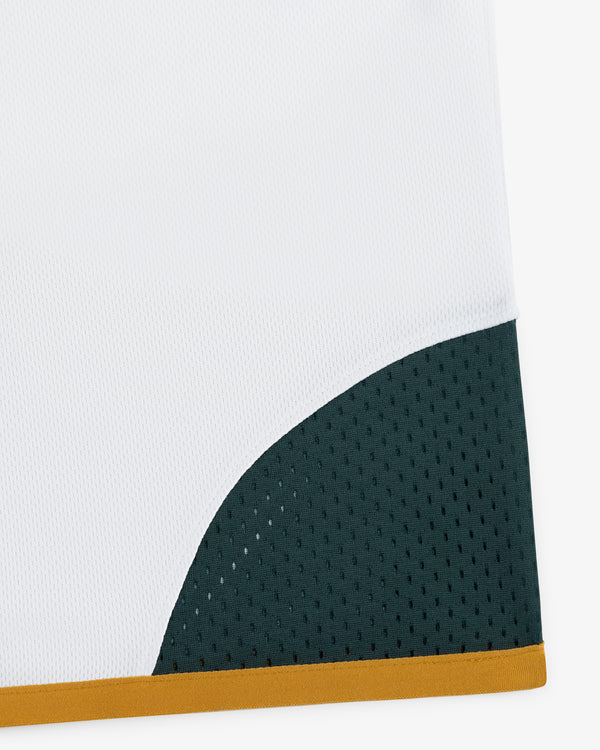 The ALD / Technics Soccer Jersey features white fabric, a dark green perforated corner, and a thin gold edge stripe.