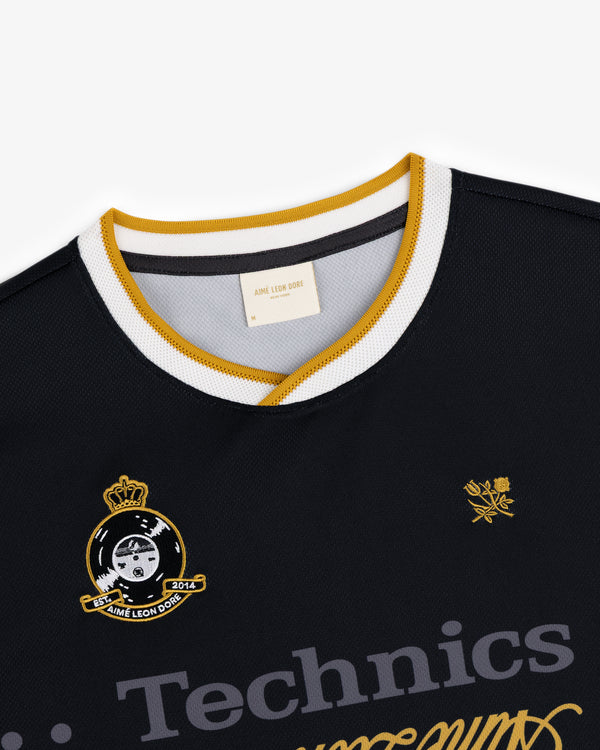 ALD / Technics Soccer Jersey: black mesh with gold and white trim, Technics logo, and embroidered chest crests.