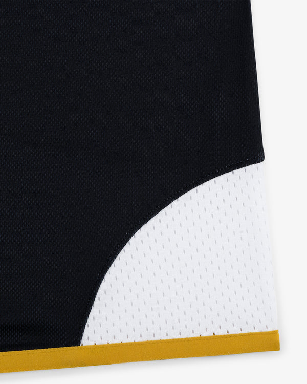 Close-up of ALD / Technics Soccer Jersey in black and white mesh with yellow trim at the bottom edge.