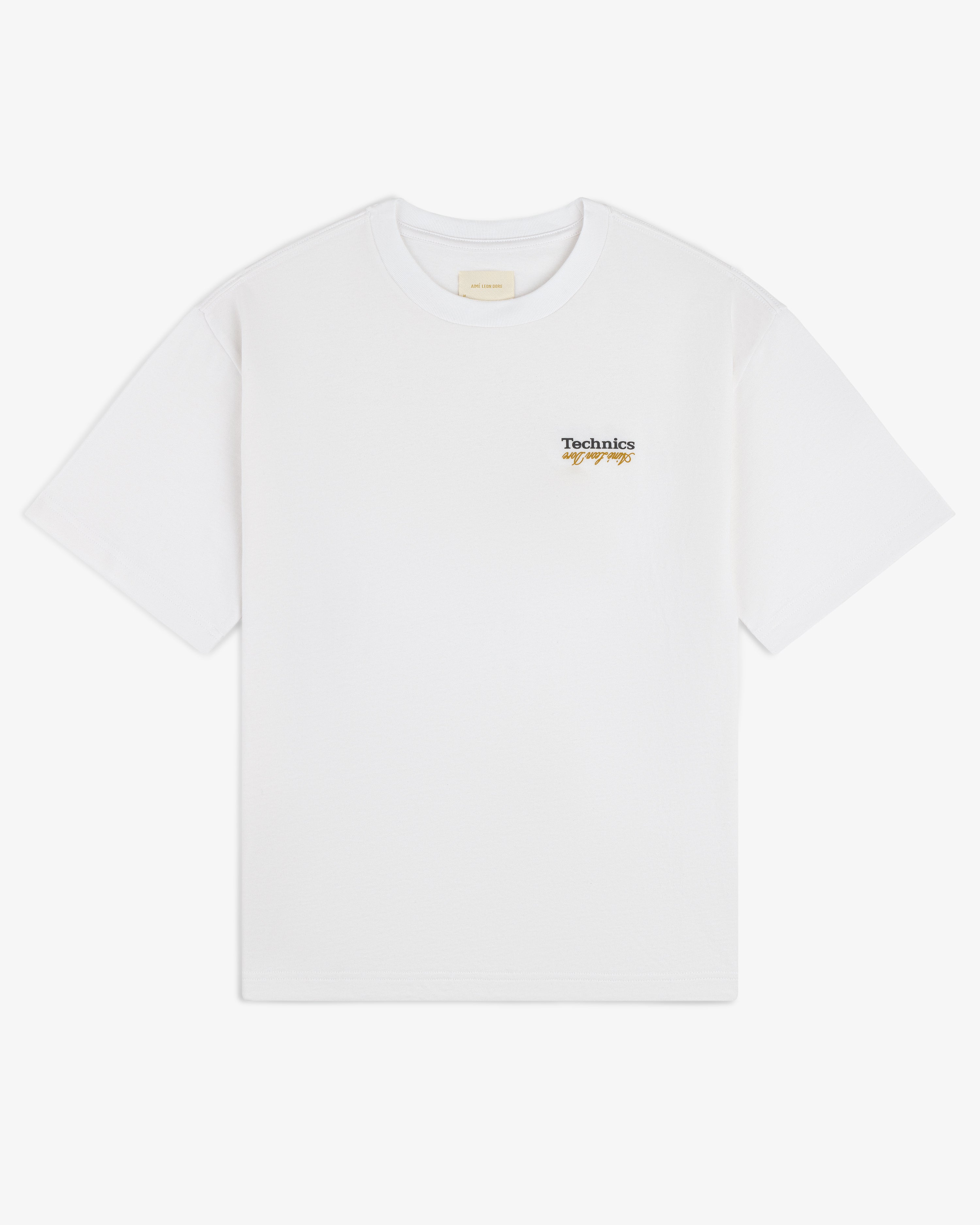 ALD / Technics Logo Tee features a small script logo on the upper left chest of a white T-shirt.