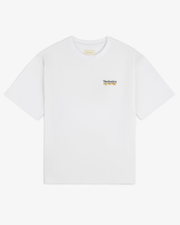 ALD / Technics Logo Tee features a small script logo on the upper left chest of a white T-shirt.