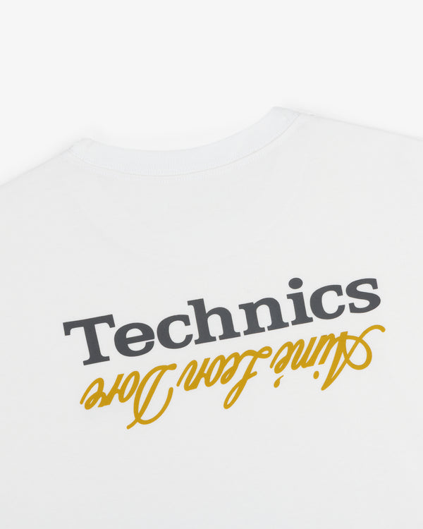 ALD / Technics Logo Tee: White tee with black Technics and yellow love script, both printed upside down.